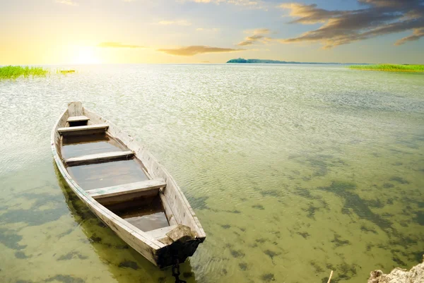 日没に対して海岸でボートします。 — ストック写真