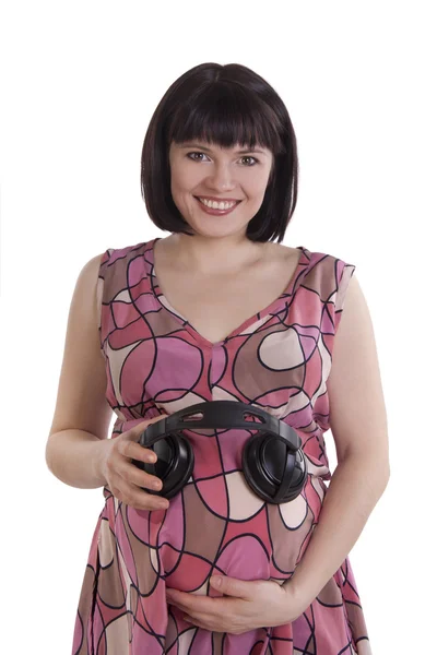 Zwangere vrouw met hoofdtelefoon op buik. — Stockfoto