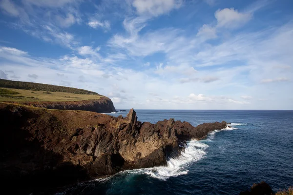 Velikonoční ostrov skalnaté pobřeží pod modrou oblohou — Stock fotografie