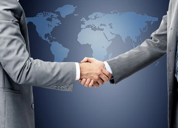 Handshake sobre mapa do mundo — Fotografia de Stock