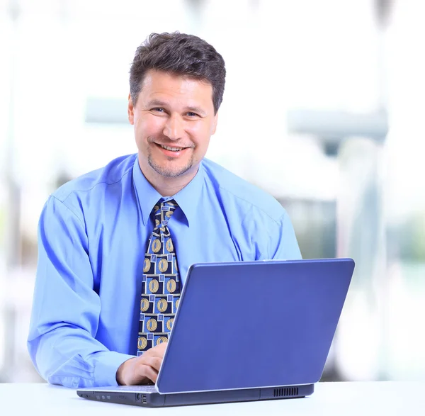 Uomo d'affari seduto alla scrivania in ufficio a lavorare sul computer portatile — Foto Stock