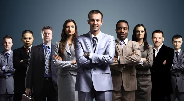 ビジネス チームは、暗い背景の上に立っている若いビジネスマンの形成 — ストック写真