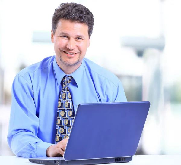 Happy executivo sentado na frente do laptop com os braços dobrados — Fotografia de Stock