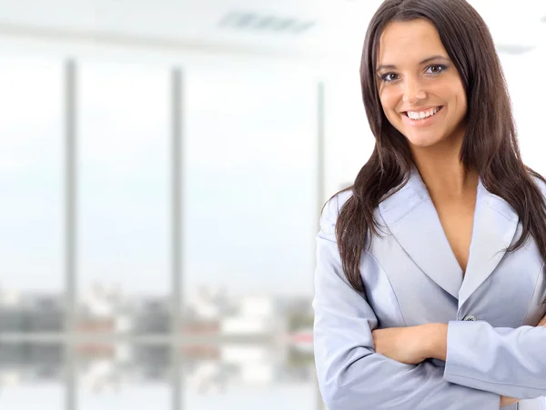 Retrato de uma jovem mulher de negócios bonito sorrindo, em um ambiente de escritório — Fotografia de Stock