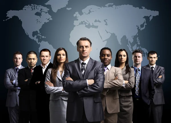 Empresários em pé em frente a um mapa da terra — Fotografia de Stock
