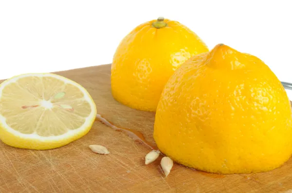 Вирізати лимона з насіння дерев'яні обробна дошка — стокове фото