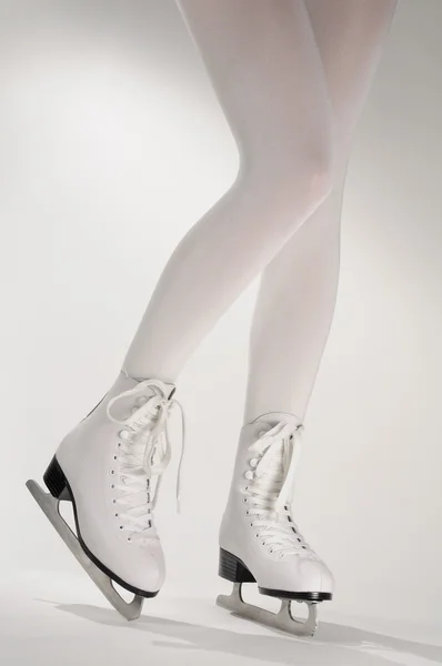 Frauenbeine in weißen Schlittschuhen — Stockfoto