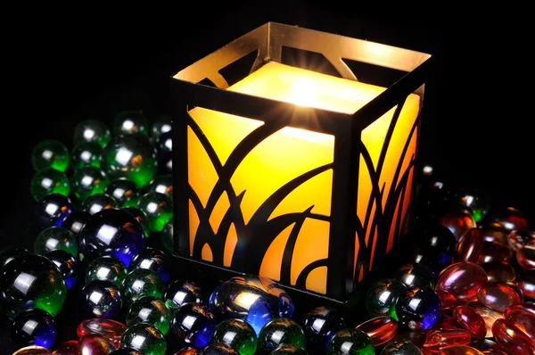 Kerzenbrennen im Dunkeln mit dekorativen Glassteinen — Stockfoto