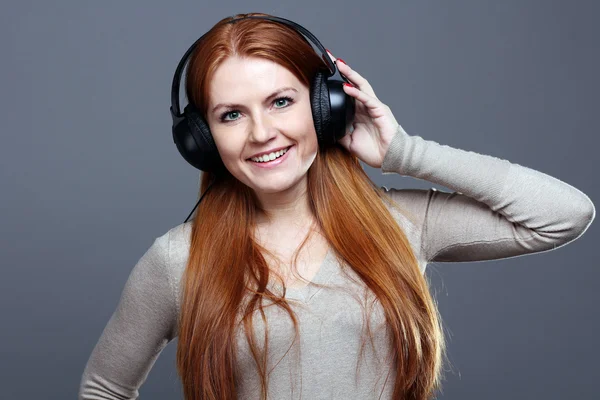 Ung kvinna lyssnar på musik — Stockfoto