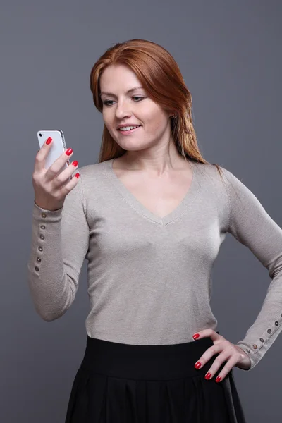 Giovane donna che mostra il telefono cellulare — Foto Stock