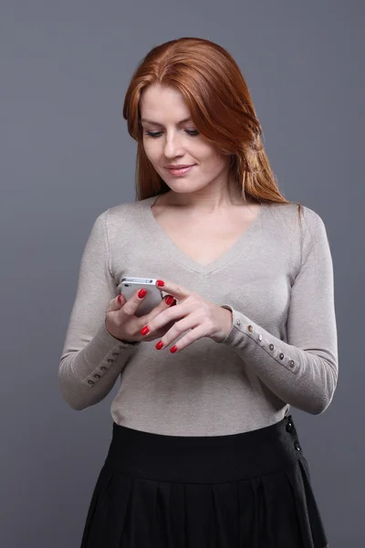 Unga kvinnliga SMS på mobiltelefon — Stockfoto