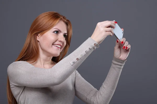 Молода жінка показує мобільний телефон — стокове фото