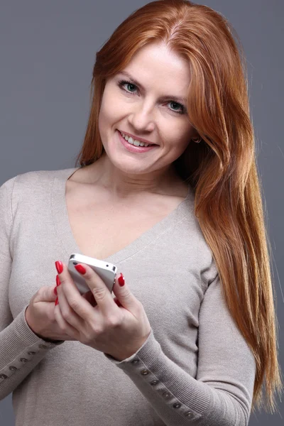 年轻女性的短信在手机上 — 图库照片