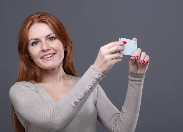 Junge Frau zeigt Handy — Stockfoto