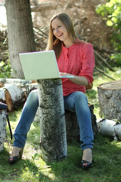 Mujer rubia divirtiéndose con el ordenador portátil al aire libre — Foto de Stock
