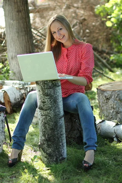 Femme blonde s'amuser avec ordinateur portable à l'extérieur — Photo