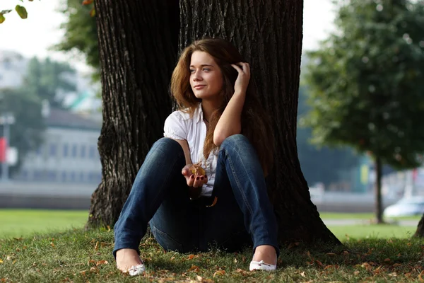 Mooi meisje zit op gras — Stockfoto