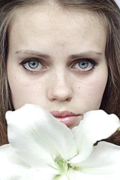 Girl behind a snow-white lily — Stock Photo, Image