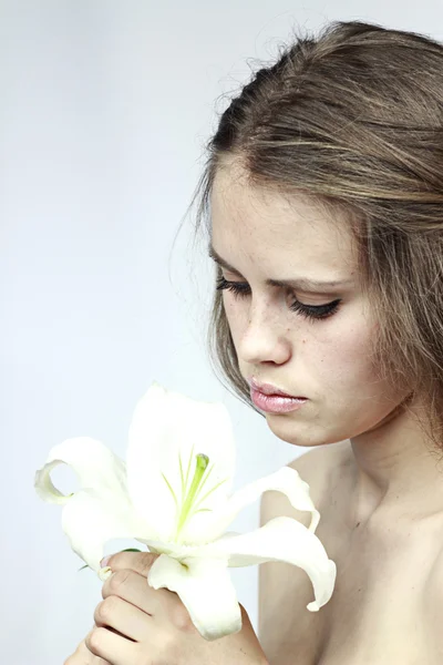 Девушка смотрит на белый цветок — стоковое фото