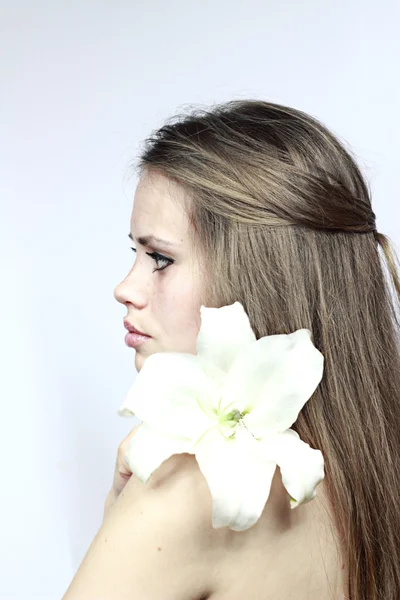 Girl with a lily looking in a distance — Stock Photo, Image