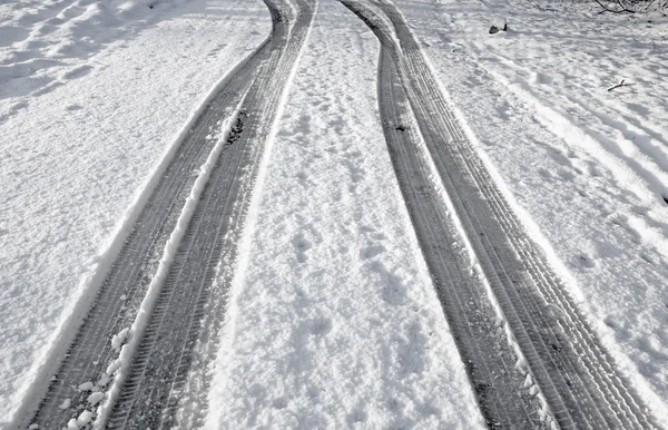 Close up tyre tracks in snow on a road. — Stock Photo, Image
