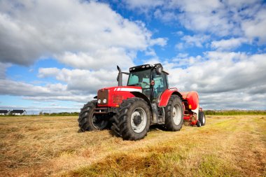 Tractor collecting haystack in the field clipart
