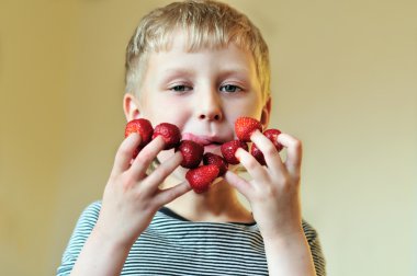 Boy eating strawberry clipart