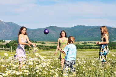 Children playing a ball in fiels clipart