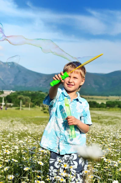 Menino soprando bolhas de sabão — Fotografia de Stock