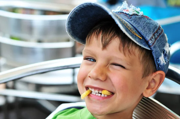 Little boy enjoying french fries — Stock Photo, Image