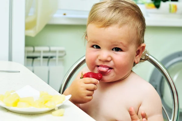 Little girl tasting strawberry — Stock Photo, Image