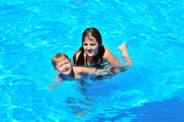 Irmã ensinando irmão a nadar — Fotografia de Stock