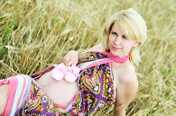 Mulher grávida que coloca no campo de trigo — Fotografia de Stock