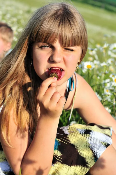 Girl liking strawberry
