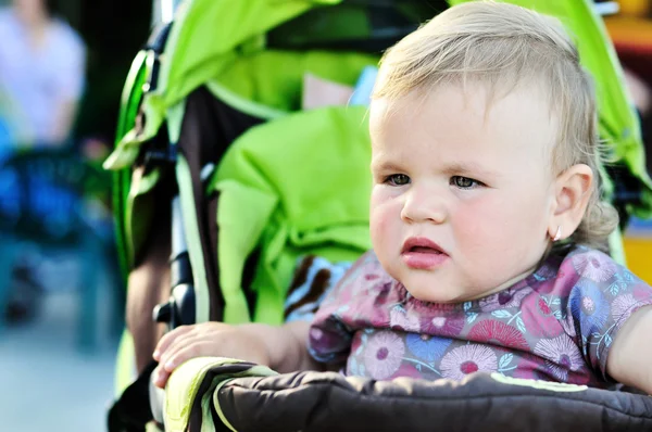 Serious girl in stroller — Stock Photo, Image
