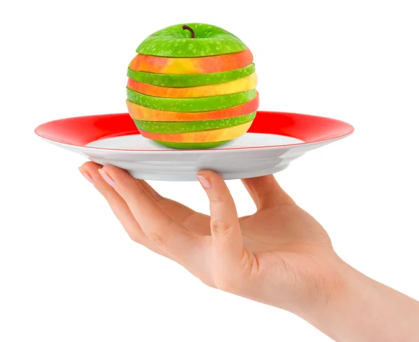 Рука с тарелкой и нарезанное яблоко — стоковое фото
