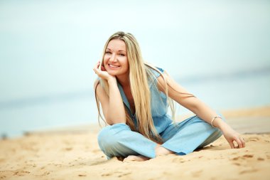 Woman resting at the beach clipart