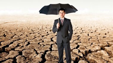 Bussinessman with umbrella in a desert clipart