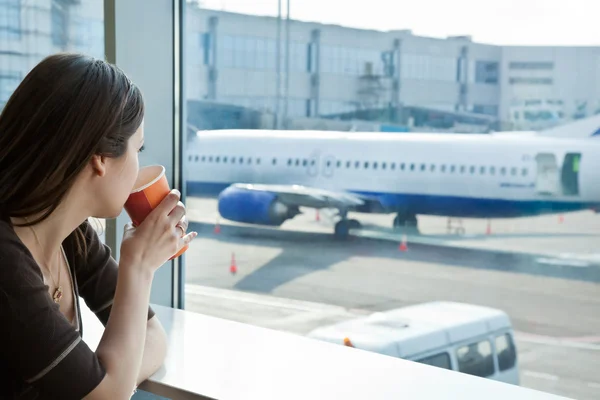 Жінка п'є каву в аеропорту — стокове фото