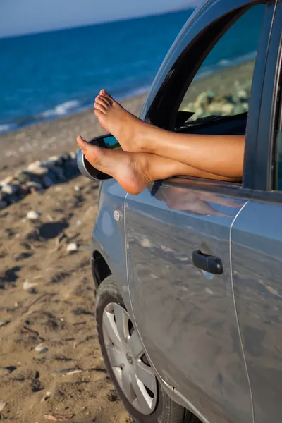 Pernas de mulher penduradas pela janela de um carro — Fotografia de Stock