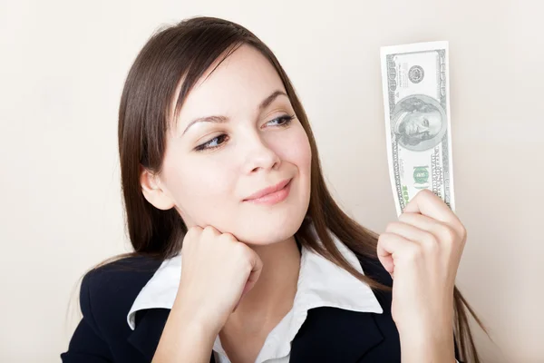 Kobieta patrzy na banknot 100 dolarów — Zdjęcie stockowe