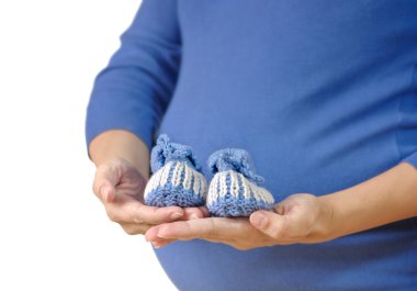 Pregnant woman holding baby booties clipart