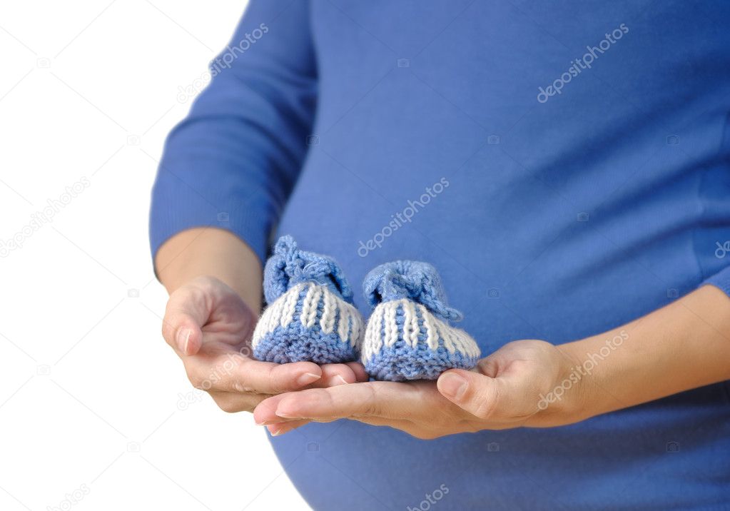 Pregnant woman holding baby booties