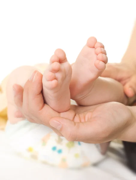 Детская нога в руке матери — стоковое фото