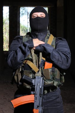 Soldier in black mask holding AK-47 gun clipart