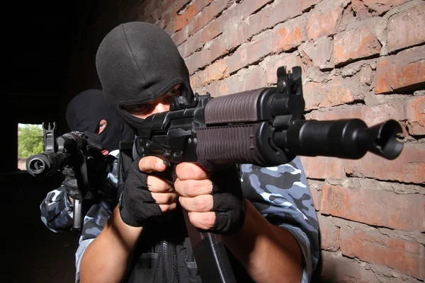 Soldados com máscaras apontando o alvo com armas — Fotografia de Stock