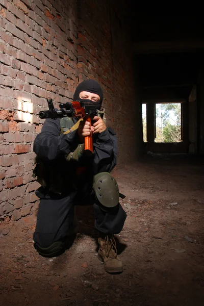 Soldado con máscara negra apuntando con un arma — Foto de Stock