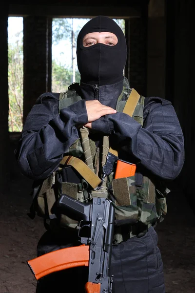 Солдат в чорній масці тримає пістолет АК-47 — стокове фото