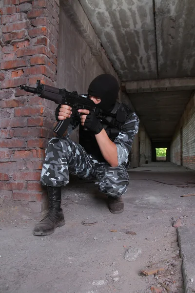 Soldaat in zwart masker richt met een pistool — Stockfoto