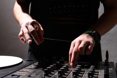 Hands of a DJ playing music from vinyl clipart